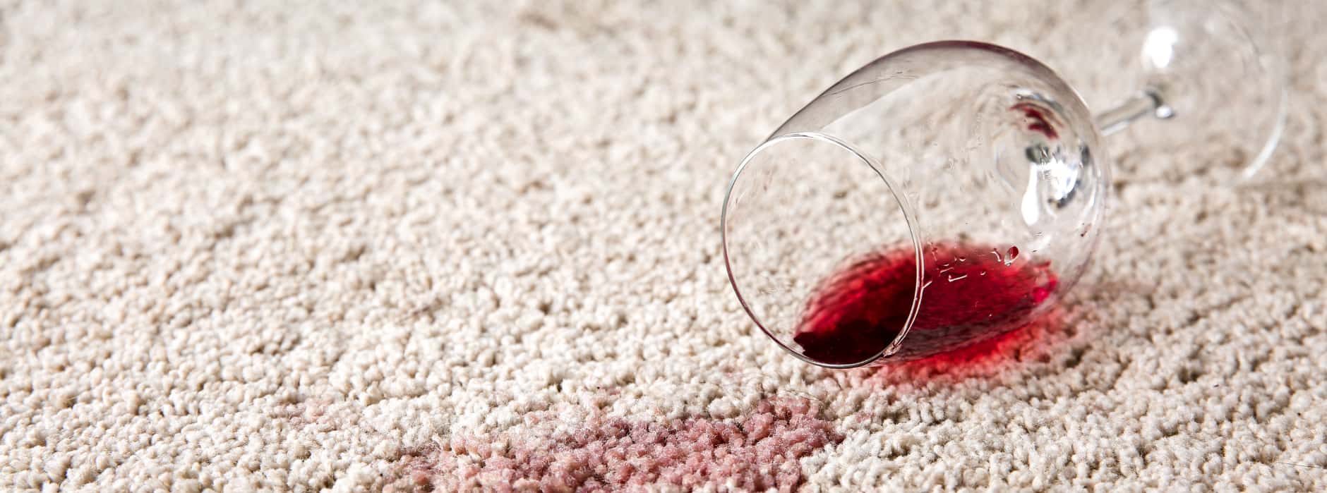 This is a photo of St Paul's Cray Carpet Cleaning red wine which has been spilt on a cream carpet. The glass is on its side.