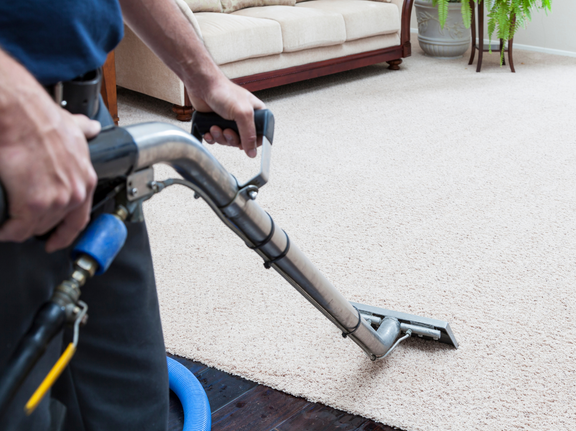 This is a photo of a man with a steam cleaner cleaning a cream carpet works carried out by St Paul's Cray Carpet Cleaning